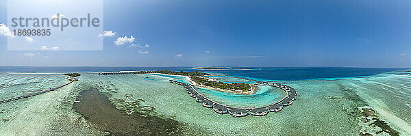 Water bungalows on Kanuhura Island under blue sky in Maldives