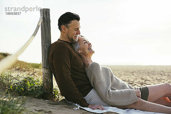 Glückliche reife Frau genießt es mit Mann am Strand