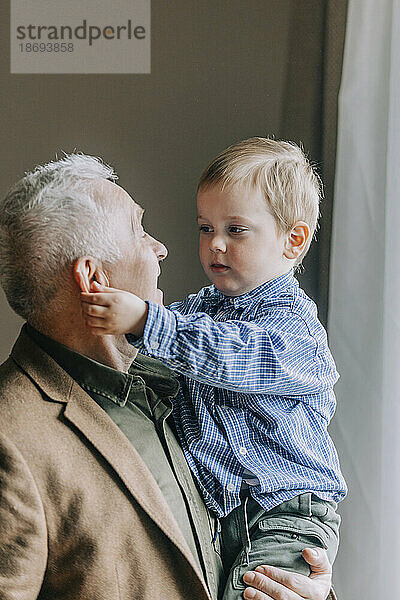Großvater trägt Enkel zu Hause