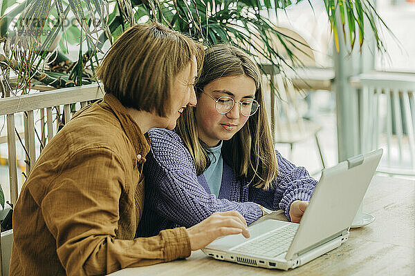 Mutter und Tochter benutzen Laptop im Café