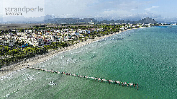 Spain  Balearic Islands  Can Picafort  Aerial view of coastal town with pier in foreground