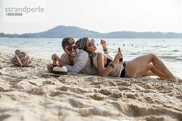 Glückliches Paar verbringt seine Freizeit im Sand am Strand