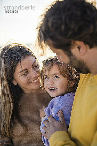 Süße Tochter mit Vater und Mutter am Strand