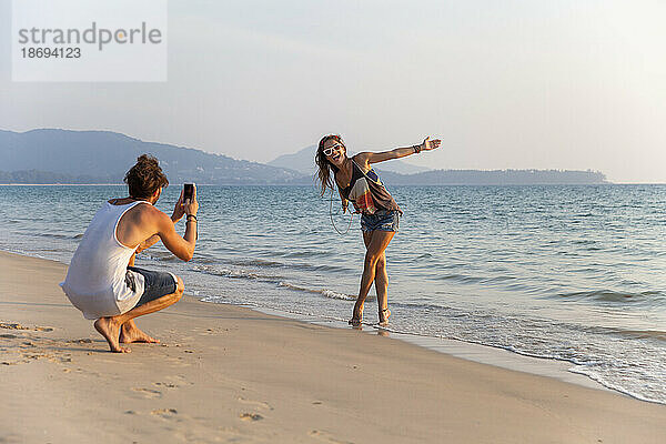 Mann fotografiert Freundin und genießt Strandnähe