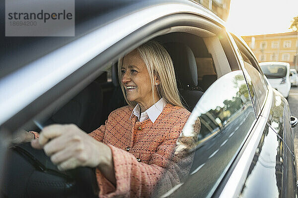 Lächelnde reife Frau  die Auto fährt