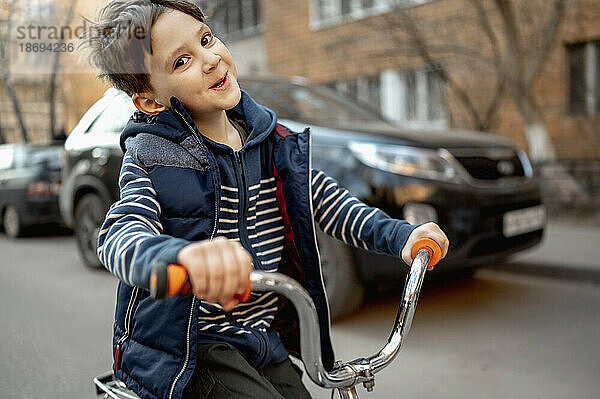 Smiling boy riding bicycle on road