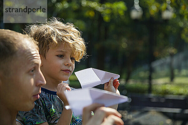 Sohn und Vater spielen mit Papierflieger