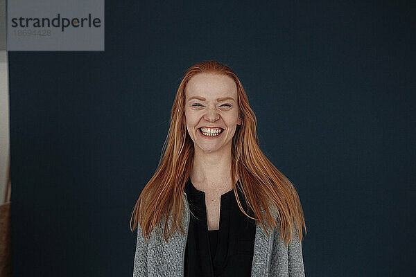 Happy redhead woman against blue background