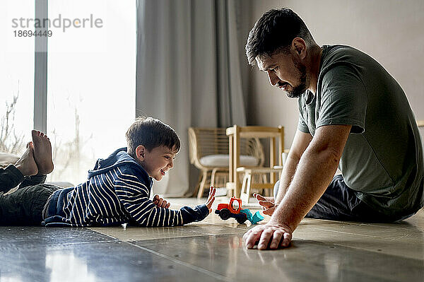 Vater und Sohn spielen zu Hause mit Spielzeug