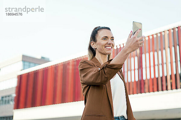 Glückliche Geschäftsfrau  die Selfie mit dem Smartphone macht