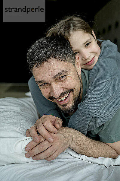 Father spending leisure time with son on bed