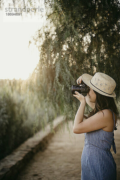 Frau fotografiert bei Sonnenuntergang mit der Kamera