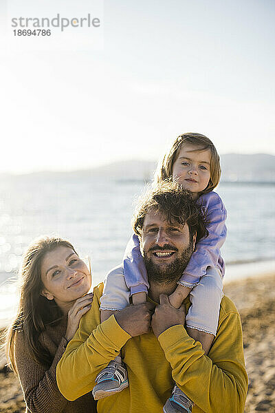 Vater und Mutter mit Tochter am Strand