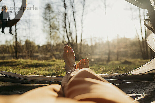Frau entspannt sich an sonnigem Tag im Zelt