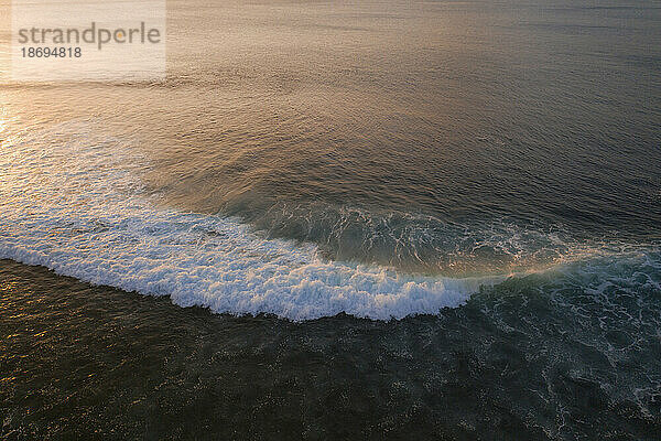 Wellen plätschern bei Sonnenuntergang im Meer