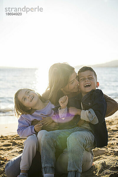 Mutter hat Spaß mit Sohn und Tochter am Strand
