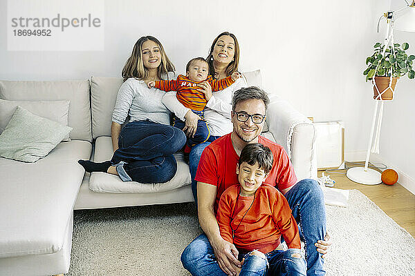 Glückliche Familie  die zu Hause zusammen im Wohnzimmer sitzt