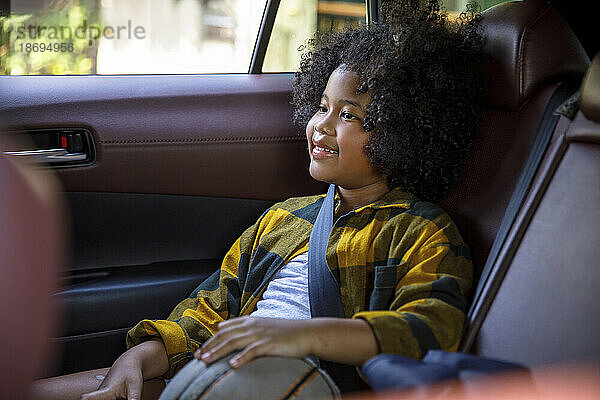 Lächelndes Mädchen sitzt auf dem Rücksitz im Auto