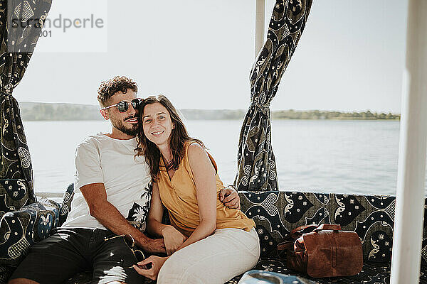 Glückliche Frau mit Mann sitzt auf Sofa im Boot