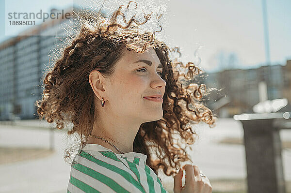 Lächelnde junge Frau mit lockigem Haar