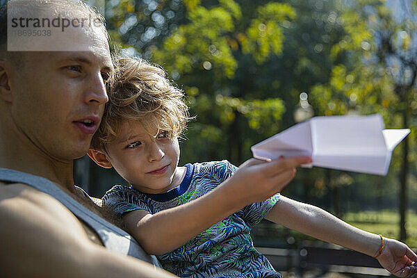 Vater und Sohn spielen mit Papierflieger