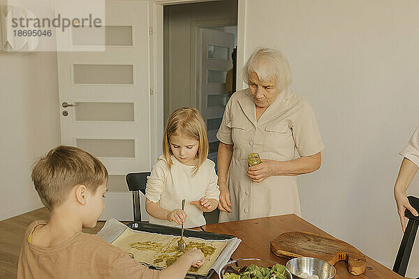 Familie mit mehreren Generationen bereitet zu Hause Essen zu