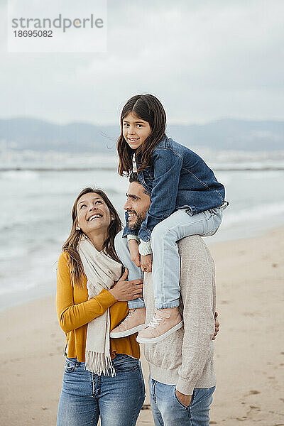 Glückliche Frau mit Familie  die am Strand genießt