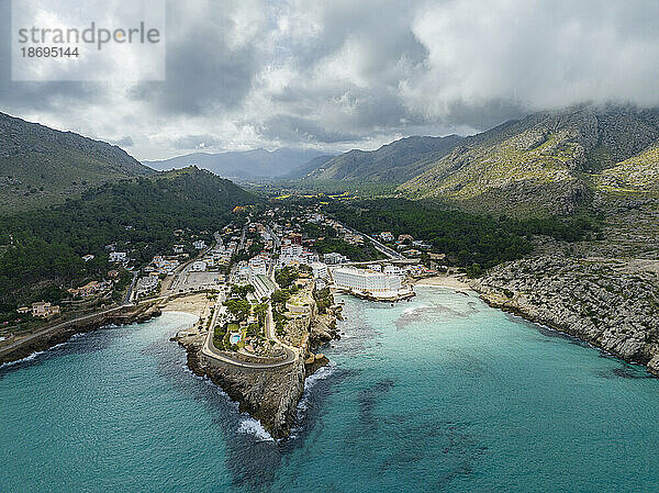 Spanien  Balearen  Cala Sant Vicenc  Luftaufnahme einer Küstenstadt mit Bergen im Hintergrund