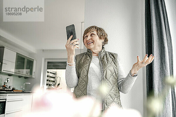 Ältere Frau führt zu Hause Videoanrufe über ihr Smartphone durch