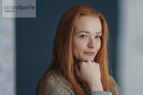 Redhead woman with hand on chin