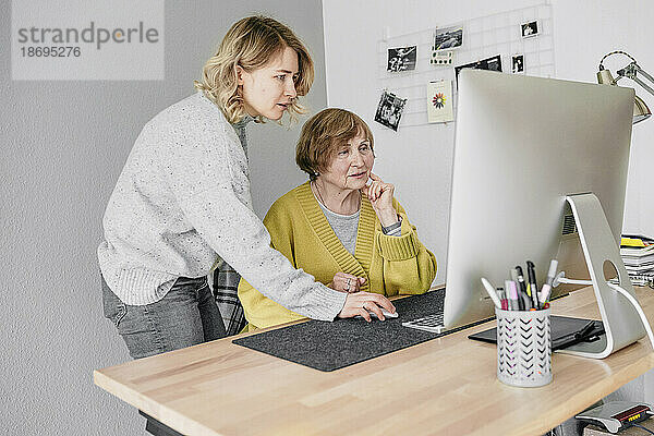 Großmutter und Enkelin benutzen Computer zu Hause