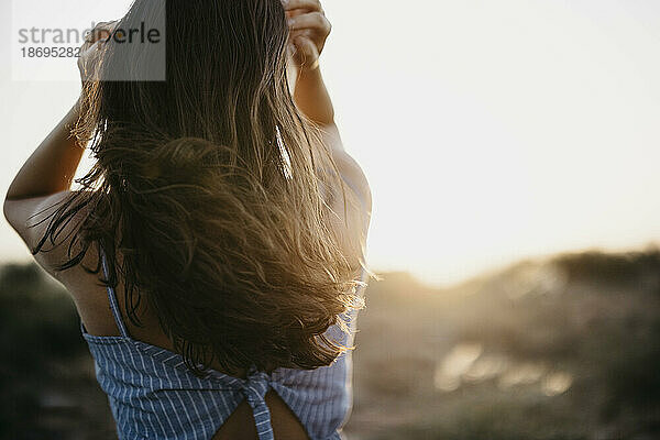 Frau mit langen Haaren bei Sonnenuntergang