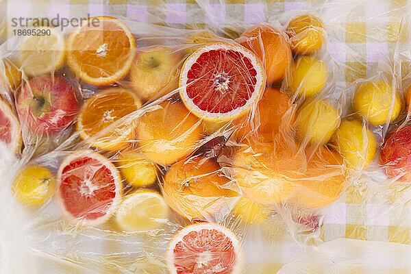 Fresh citrus fruits on table covered with plastic sheet