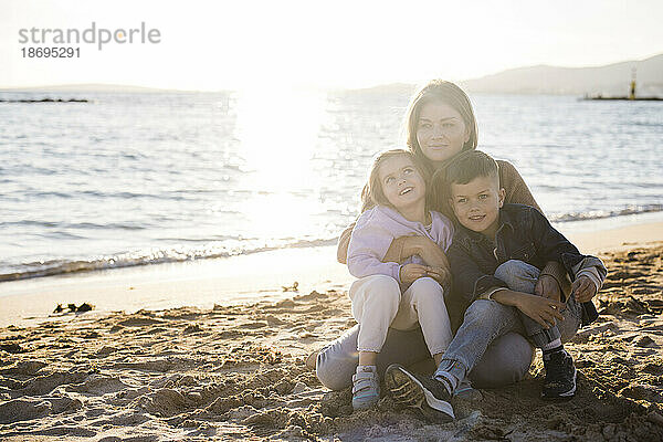 Frau verbringt Freizeit mit Sohn und Tochter am Strand