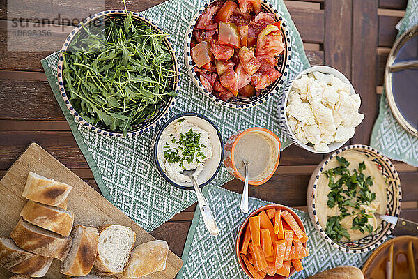 Verschiedene gesunde Mahlzeiten in Schüsseln mit veganen Produkten auf dem Tisch