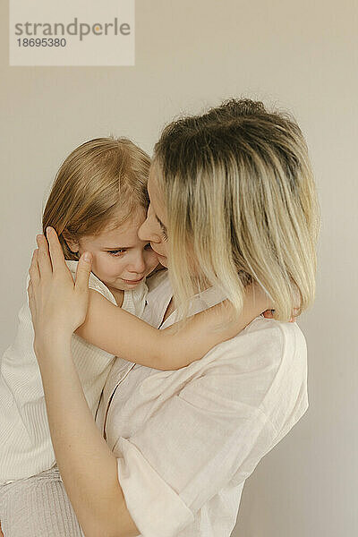 Mutter tröstet traurige Tochter zu Hause