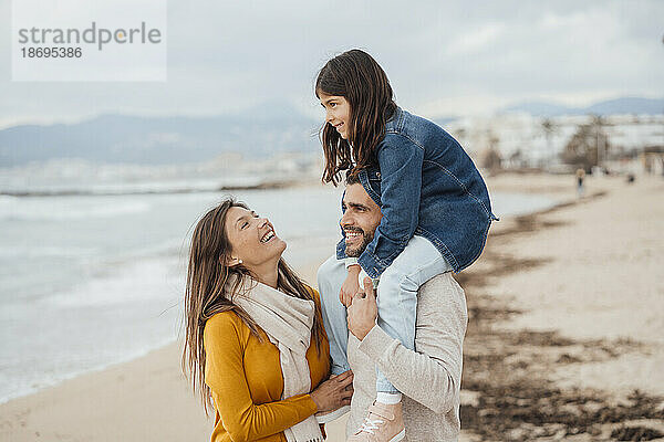 Glückliche Frau mit Familie genießt Urlaub am Strand