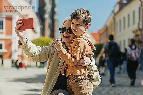 Mutter macht im Urlaub ein Selfie mit ihrem Sohn per Smartphone