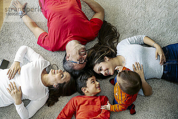 Happy family lying down on carpet at home