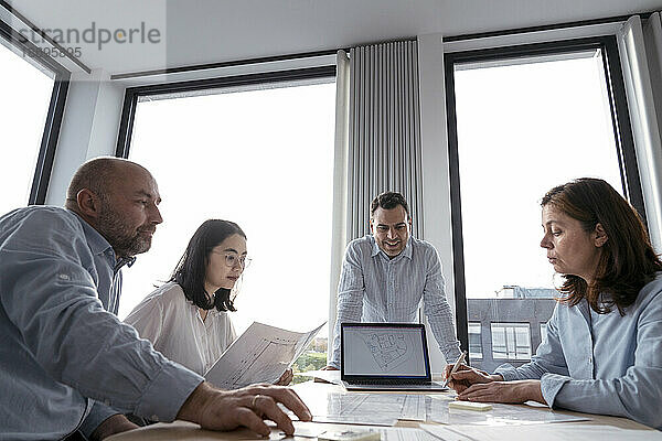 Geschäftsleute arbeiten gemeinsam an einem Architekturprojekt im Büro