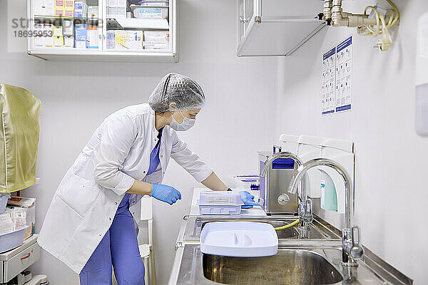 Chirurg arbeitet in der Nähe des Waschbeckens im Operationssaal