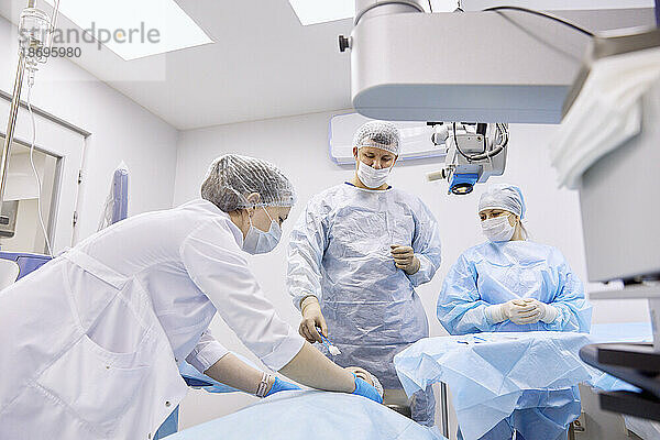 Arzt und Krankenschwester bereiten sich im Operationssaal auf eine Augenoperation vor