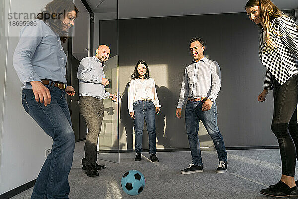 Geschäftskollegen spielen Fußball im Büro