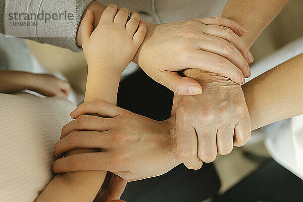 Family holding hands of each other at home