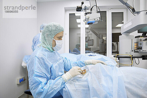 Chirurg untersucht das Auge des Patienten im Operationssaal