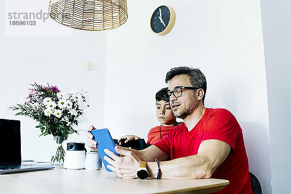 Vater teilt Tablet-PC mit Sohn zu Hause