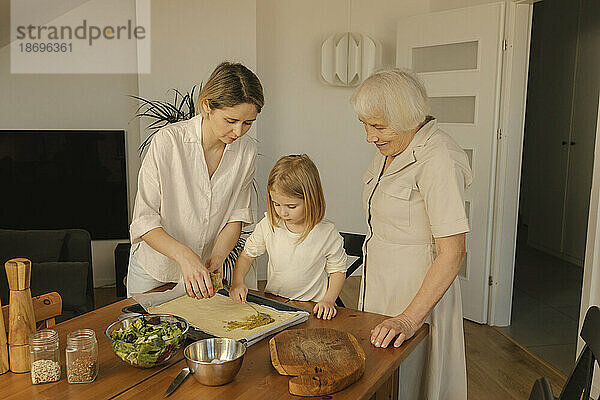 Familie hilft sich gegenseitig beim Zubereiten von Essen zu Hause