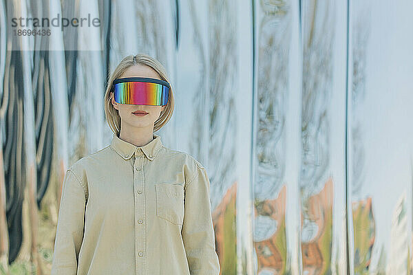 Frau mit futuristischer Brille vor Metallkonstruktion
