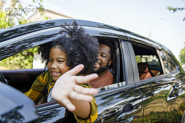 Lächelnde Tochter genießt Roadtrip mit Vater im Auto