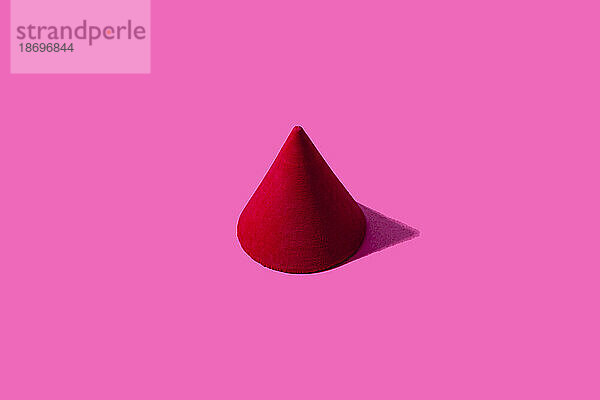 3D-Darstellung eines roten Kegels vor rosa Hintergrund
